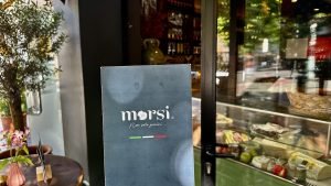 photo of close up of morsi tirana menu cover in front of store