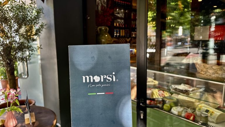 photo of close up of morsi tirana menu cover in front of store